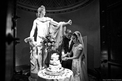 Cutting cake next the Apollo statue in the Sculpture Gallery at Woburn Abbey. Guy Collier wedding photography